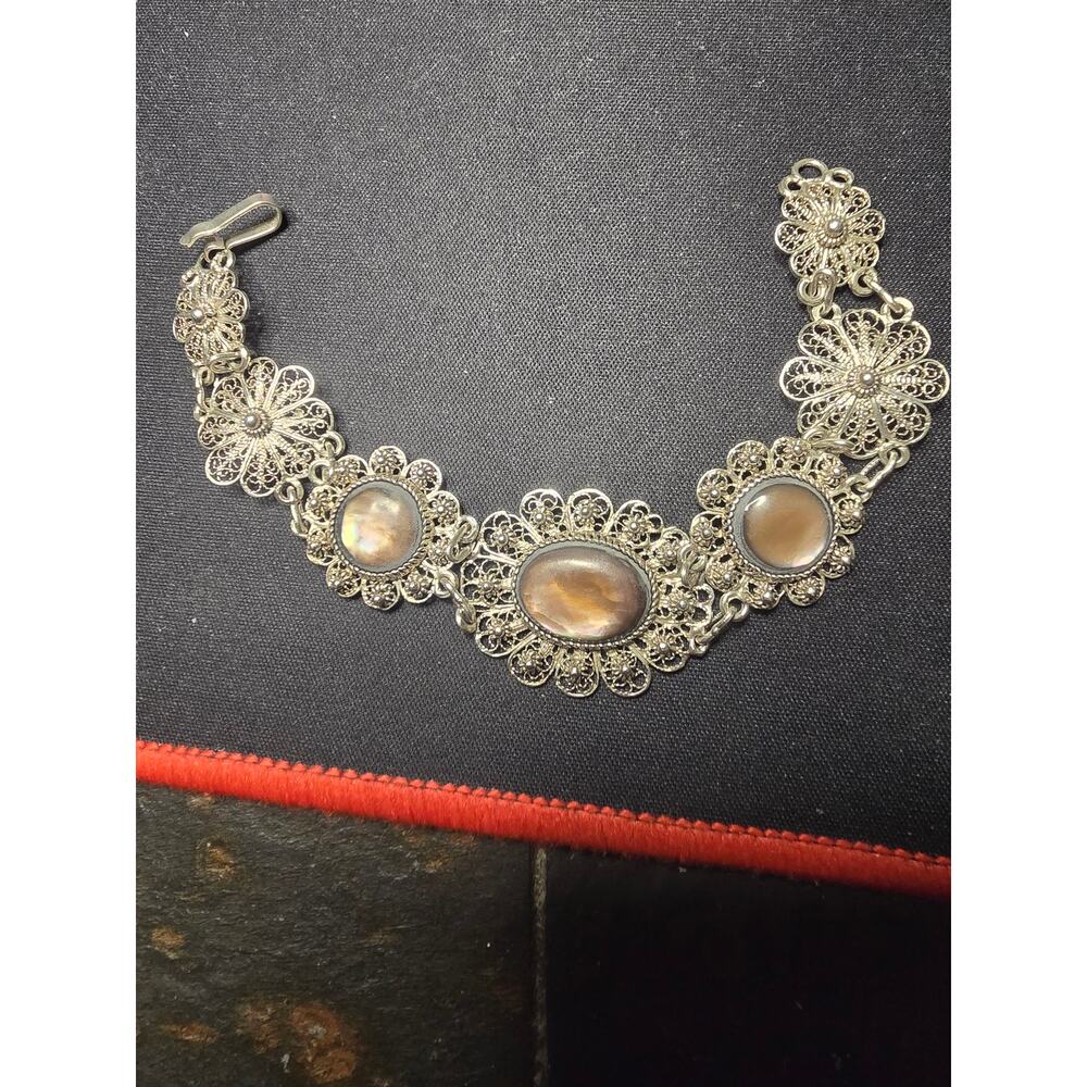 Vintage sterling silver filigree bracelet featuring mother-of-pearl cabochons